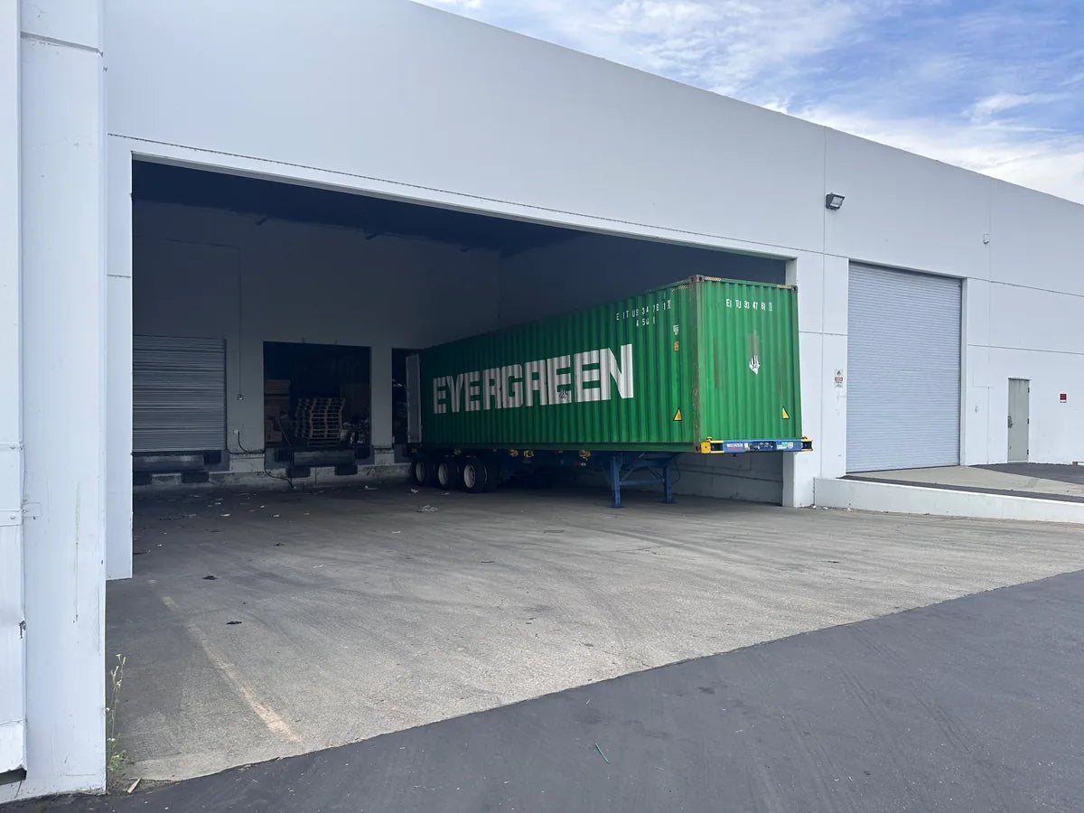 Shipping container positioned at a warehouse loading dock