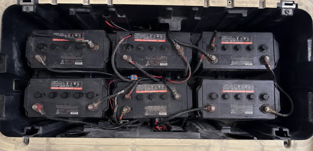 Old lead-acid golf cart batteries installed in the battery compartment before lithium replacement