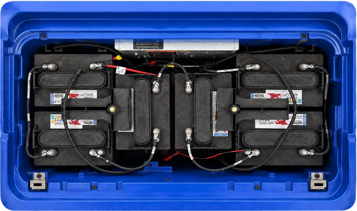 Old lead-acid golf cart batteries installed in the battery compartment before lithium replacement