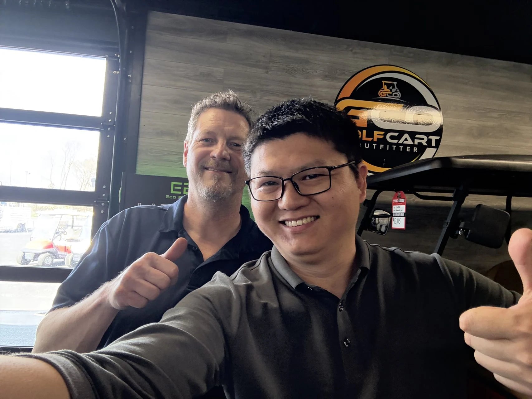 Two people photographed during a visit inside a golf cart shop